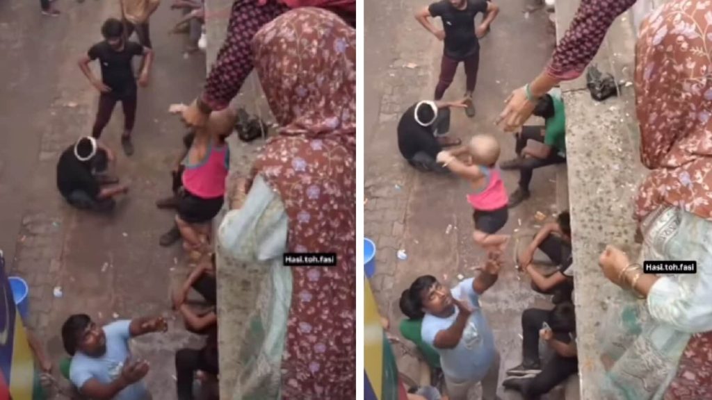 એક સ્ત્રી છતની ધાર પર અને એક બાળકને એક હાથથી ખતરનાક રીતે વળાંક આપે છે … एक महिला छत के किनारे पर खतरनाक तरीके से झुकती है और एक हाथ से एक बच्चे को...